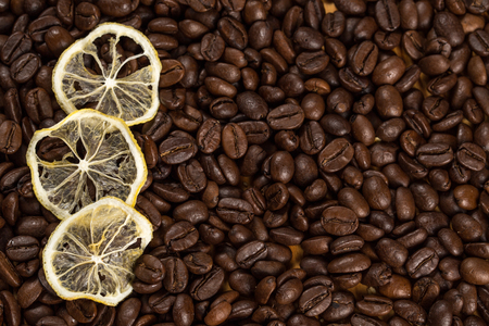 Gifts of nature. Shot of roasted coffee beans with three lemon slices lying on them copyspace.の写真素材