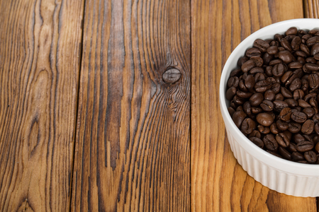 Caffeine. Cropped shot of aromatic coffee beans in a bowl on a wooden table copyspace on the side.の写真素材