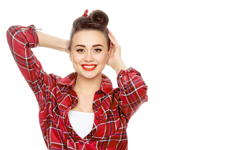 Young and beautiful. Stunning young woman with vintage pinup hairstyle and makeup smiling to the cameraの写真素材