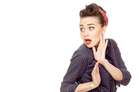 Total madness. Stunning young pinup woman wearing red headband and classic retro makeup and hairstyle looking shocked at the copyspace on the sideの写真素材