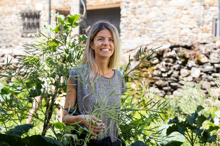 woman with blonde hair and big smile in a village surrounded by natureの写真素材