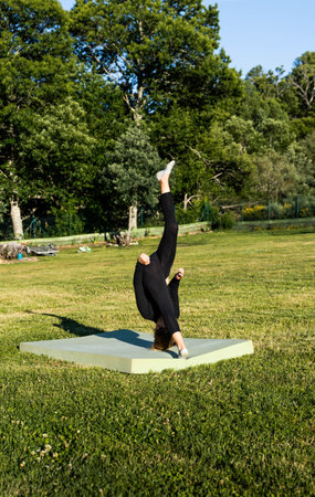 Girl with blonde hair doing the handstand without hands in rural landscapeの写真素材