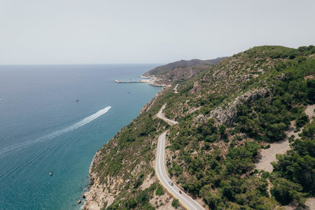 Aerial view of drone about road between green mountain with road and blue mediterranean seaの写真素材