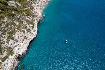 drone view between a mediterranean sea and a coastline with a boat in the seaの写真素材