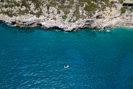 drone view between a mediterranean sea and a coastline with a boat in the seaの写真素材