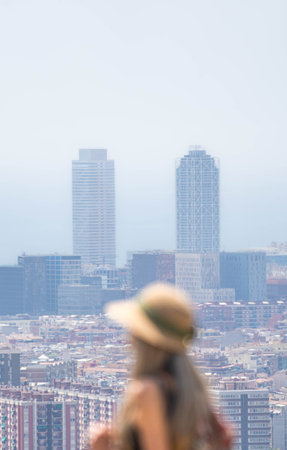 Unrecognizable woman with long blonde hair and hat at the viewpoint of Barcelonaの写真素材