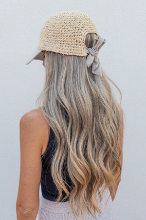 Portrait backward of woman with blonde long hair and capの写真素材