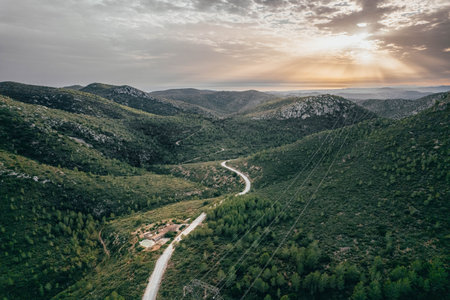 Drone view of savage road in the middle of the green forest and mountainsの写真素材