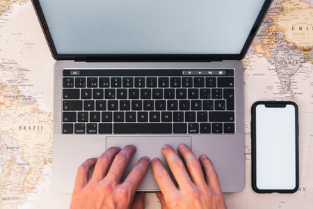 Unrecognizable person using laptop, searching and planning holidaysの写真素材