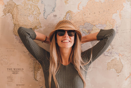 Portrait of caucasian young blonde woman looking at the camera near vintage mapの写真素材
