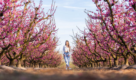 Blonde woman in a field of pink flowers in Aitona with sunglasses in spring