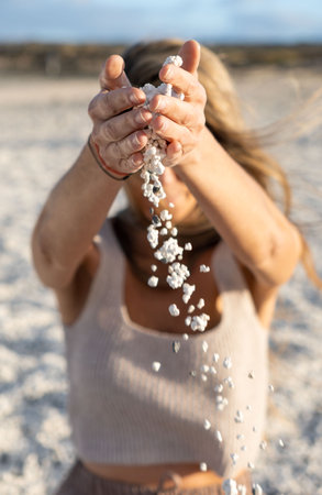 Popcorn beach. Defocused blonde woman throwing pebbles on the beach. Fuerteventuの写真素材