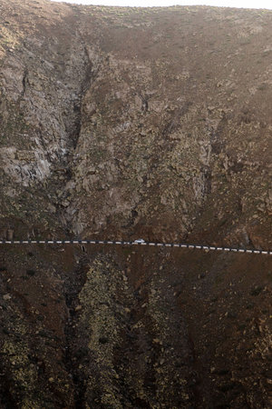 White car in the middle of mountain road. Contrast in the landscapeの写真素材