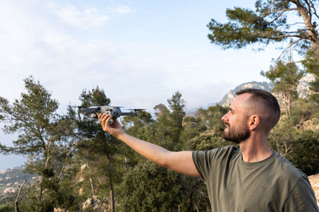 Young man holding drone before flight in the nature.Guy prepare to pilot outdoorの写真素材