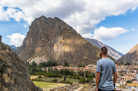 Rear view of caucasian man looking Inca Terraces and Hill in Ollantaytambo, Peruの写真素材