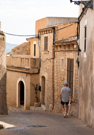 Rear view of young man walking alone through the street of the villageの写真素材