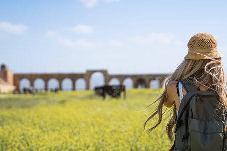 Rear view of tourist blonde woman with hat and long hair in Ancient Jerash ruins, Jordanの写真素材