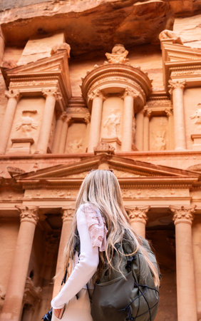 Rear view of blonde woman in spectacular view of Al Khazneh (The Treasury), ancient city of Petra, Jordanの写真素材