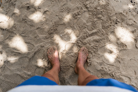 Man in swimsuit barefoot on the beachの写真素材