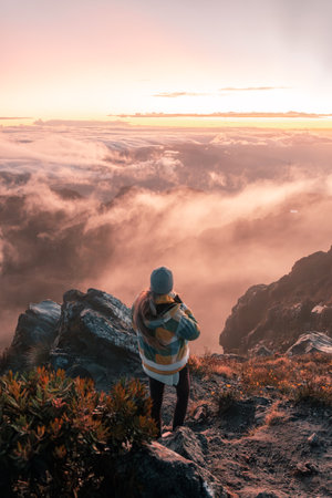 Woman on top of a mountain gazing the cloudy views