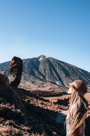 A woman gazes upward at a unique rock formation Roque Cinchado with a Teideの写真素材