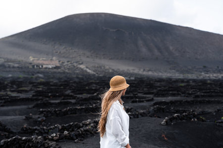 Rear view of woman in La Geria, vineyard wine landscape of volcanic in Lanzaroteの写真素材