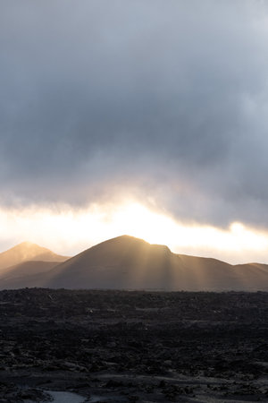 Stunning sunset highlights mountains against dramatic cloudy skyの写真素材