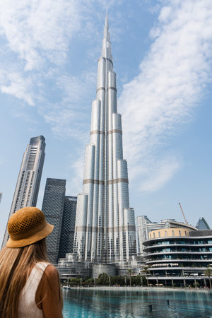 Blonde tourist admiring the burj khalifa in dubai, united arab emiratesの写真素材
