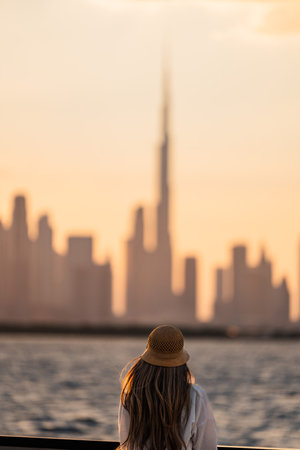 Rear view tourist admiring dubai skyline at sunset from a boat trip perspectiveの写真素材