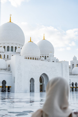Muslim woman wearing a khimar contemplating sheikh zayed mosque in abu dhabi
