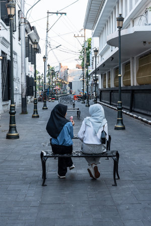 Unrecognizable Two muslim women wearing hijab enjoying ice cream in kota tua, jakarta, indonesiaの写真素材