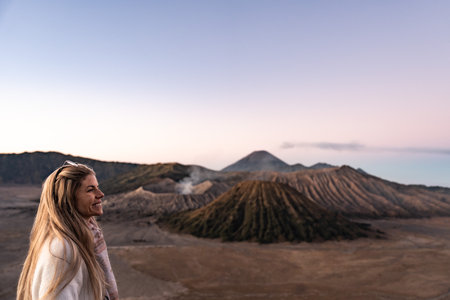 Woman enjoying sunrise at mount bromo viewpointの写真素材