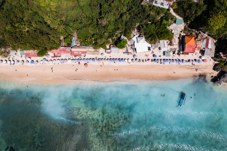 Tourists enjoying padang padang beach in bali, indonesia, from aboveの写真素材