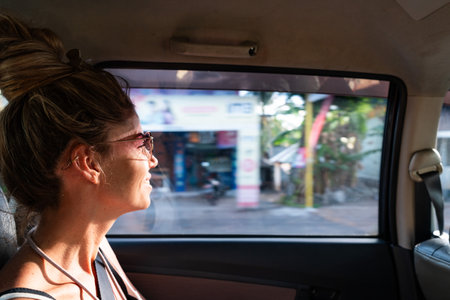 Tourist exploring bali from car window enjoying indonesian cultureの写真素材