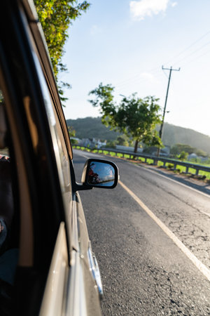 POV car driving on country road reflecting in rearview mirrorの写真素材