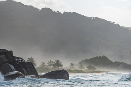 Ocean waves crashing on rocks in tayrona national park, colombiaの写真素材