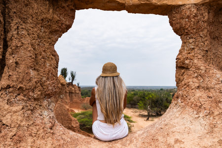 Young woman enjoying colombian desert view through rock formation