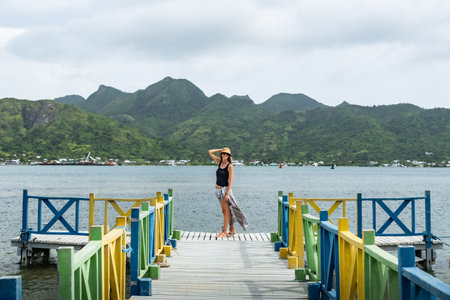 Tourist enjoying colorful pier in baru island, colombia, with scenic mountain view in Providencia