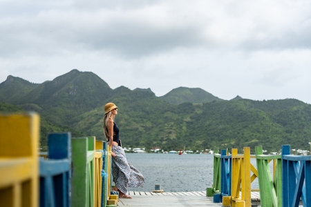 Tourist enjoying breathtaking view of colombian archipelago from colorful pier in Providencia