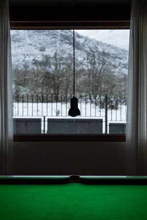 Billiard table in a room overlooking snowy landscape