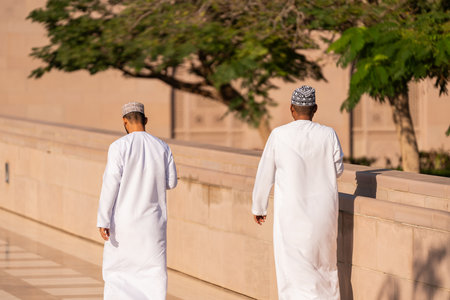 Unrecognizable omani men wearing traditional clothing walking togetherの写真素材