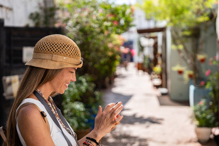Woman traveling using smartphone in picturesque streetの写真素材