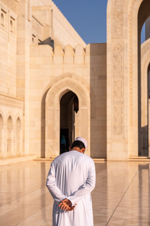 Unrecognizable muslim man contemplating at sultan qaboos grand mosque in omanの写真素材