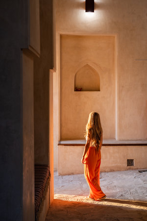 Woman discovering oman heritage architecture alleyway during travelの写真素材