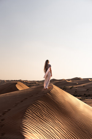 Woman exploring desert sand dunes enjoying oman travel lifestyleの写真素材