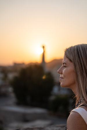 Woman contemplating sunset over city minaret in omanの写真素材