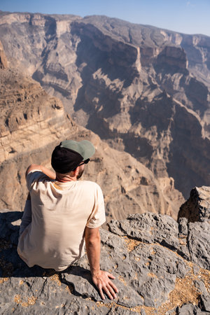 Traveler contemplating vast jebel shams canyon in omanの写真素材