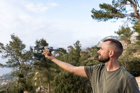 Young man holding drone before flight in the nature.Guy prepare to pilot outdoor