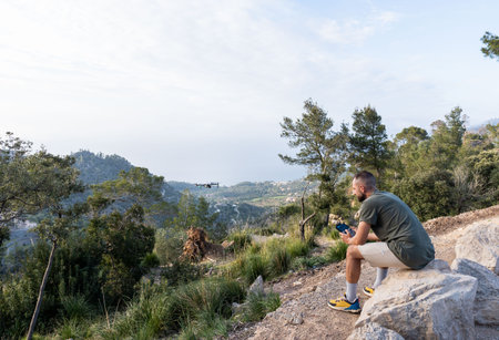 Man operating the drone by remote control and having fun