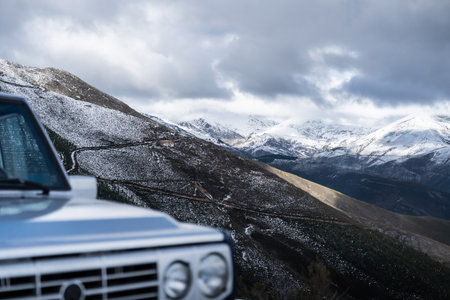 Off-road vehicle driving winding mountain road in winterの写真素材